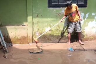 Seorang warga membersihkan lumpur sisa-sisa banjir yang masuk ke dalam rumah dan halaman di kawasan Kebon Pala, RW 04 dan RW 05, Kampung Melayu, Jatinegara, Jakarta Timur, Minggu (10/11/2024) siang. Foto: Ist