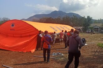 Badan Nasional Penanggulangan Bencana (BNPB) memasang tenda-tenda untuk menampung para pengungsi yang akan dipindahkan di Kampung Kanada, Desa Kobasoma, Kecamatan Titehena, Kabupaten Flores Timur, Nusa Tenggara Timur, Minggu (10/11/2024) sore. Foto: BNPB