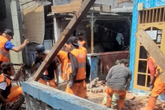 Sejumlah pasukan orange mengevakuasi membersihkan puing sisa bangunan atap unit rumah warga di Jalan H. Ahyar, RT 06/RW 05, Kelurahan Duren Sawit, Kecamatan Duren Sawit, Jakarta Timur, yang roboh, Senin (11/11/2024). Foto: Ist