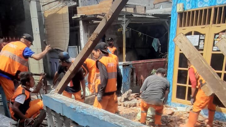 Sejumlah pasukan orange mengevakuasi membersihkan puing sisa bangunan atap unit rumah warga di Jalan H. Ahyar, RT 06/RW 05, Kelurahan Duren Sawit, Kecamatan Duren Sawit, Jakarta Timur, yang roboh, Senin (11/11/2024). Foto: Ist