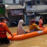 Petugas Badan Penanggulangan Bencana Daerah (BPBD) Kabupaten Bandung melakukan evakuasi Ibu-Ibu dengan perahu karet di wilayah Kota dan Kabupaten Bandung, Jawa Barat. Debit air Sungai Citarum meningkat dan meluap ke permukiman, Senin (25/11/2024). Foto: Ist