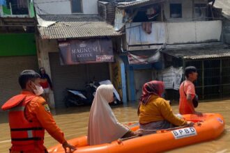 Petugas Badan Penanggulangan Bencana Daerah (BPBD) Kabupaten Bandung melakukan evakuasi Ibu-Ibu dengan perahu karet di wilayah Kota dan Kabupaten Bandung, Jawa Barat. Debit air Sungai Citarum meningkat dan meluap ke permukiman, Senin (25/11/2024). Foto: Ist