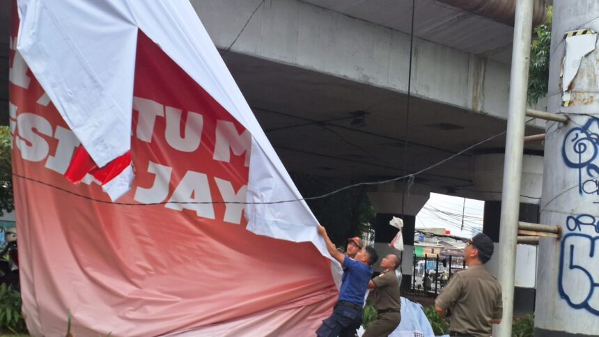 Masa tenang, puluhan petugas gabungan melakukan penurunan tiga alat peraga kampanye (APK) bakal calon gubernur dan calon wakil gubernur DKI di wilayah Jakarta Timur, Senin (25/11/2024) siang. Foto: Ist