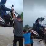 Seorang guru SD di Banyuasin digotong bersama motornya oleh warga untuk melewati banjir menuju sekolah. Foto: Tangkapan layar X @pai_c1