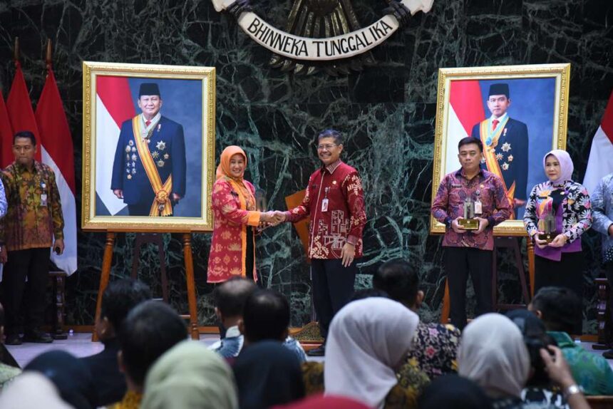 Plt) Kota Administrasi Jakarta Timur, Iin Mutmainnah, saat menerima penghargaan Keterbukaan Informasi Publik dari DKI Jakarta 2024 oleh Sekda DKJ Marullah Matali, Kamis (19/12/2024). Foto: Ist