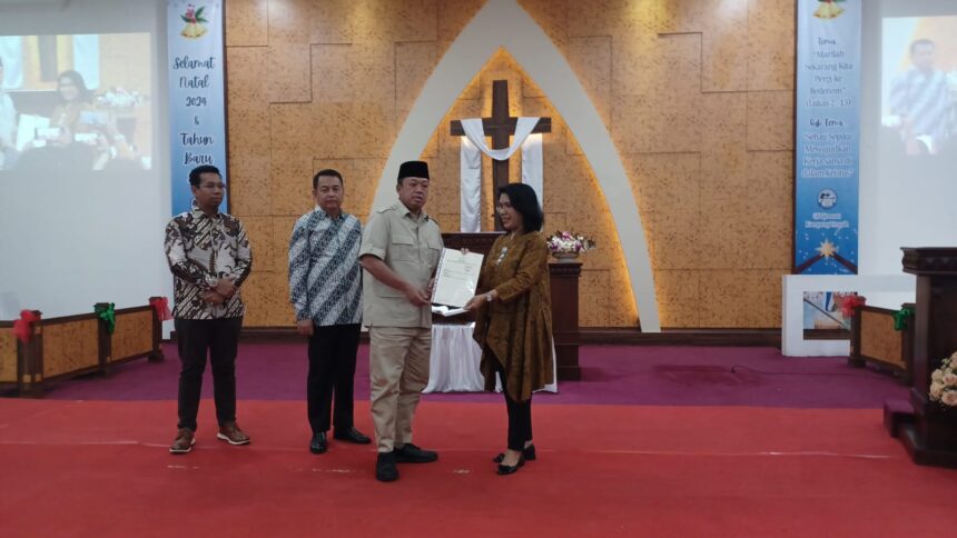 Menteri Agraria dan Tata Ruang/Badan Pertanahan Nasional Republik Indonesia, Nusron Wahid menyerahkan langsung Sertipikat Hak Milik (SHM) kepada Ketua Umum Majelis Sinode Gereja Kristen Pasundan (GKP), Pendeta Magyolin Carolina Tuasuun di GKP Jemaat Kampung Tengah, RW 08, Kramat Jati, Selasa (24/12/2024). Foto: Joesvicar Iqbal/ipol.id