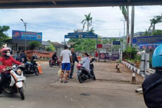 Sejumlah pengendara motor dan mobil yang ingin membayar pajak perpanjangan STNK sempat menunggu informasi dan juga yang langsung pergi di depan gerbang Samsat Jakarta Timur, pada Kamis (26/12/2024) siang. Foto: Joesvicar Iqbal/ipol.id