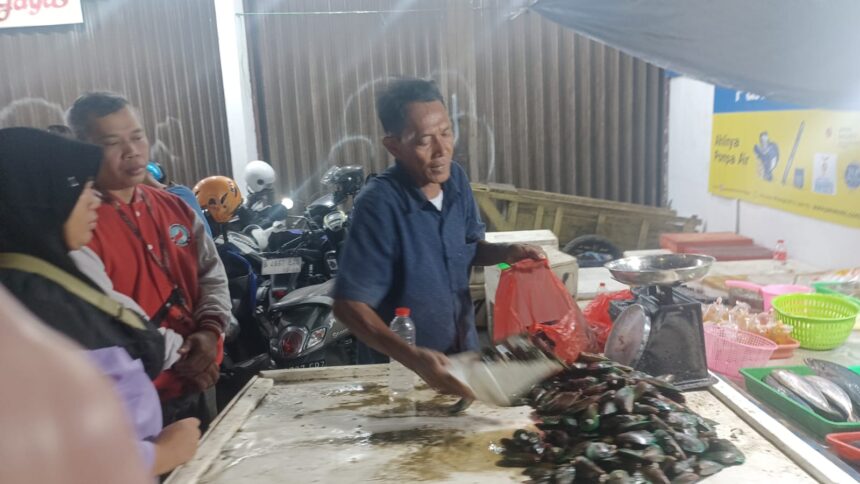 Para pedagang kerang, ikan dan cumi diserbu pembeli di Jalan Raya Bogor, Kramat Jati, Jakarta Timur, pada Senin (30/12/2024) malam. Pedagang mendapatkan berkah menjelang pergantian tahun baru. Foto: Joesvicar Iqbal/ipol.id