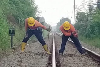 Dua petugas melakukan pemeliharaan terhadap jalur kereta api. Foto: KAI