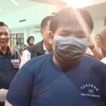 Tersangka George Sugama Halim mengenakan baju tahanan dihadirkan dalam konfrensi pers kasus penganiayaan pegawai toko roti di Mapolres Metro Jakarta Timur, Senin (16/12/2024) sore. Foto: Joesvicar Iqbal/ipol.id