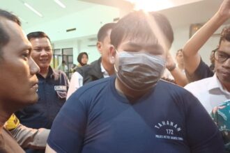 Tersangka George Sugama Halim mengenakan baju tahanan dihadirkan dalam konfrensi pers kasus penganiayaan pegawai toko roti di Mapolres Metro Jakarta Timur, Senin (16/12/2024) sore. Foto: Joesvicar Iqbal/ipol.id