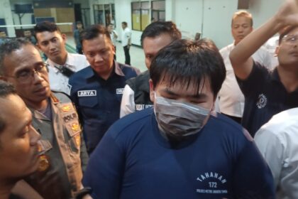 Tersangka George Sugama Halim (mengenakan kaos tahanan dan masker) saat dihadirkan dalam pengungkapan kasus penganiayaan korban perempuan pegawai toko kue di Mapolres Metro Jakarta Timur, belum lama ini. Foto: Dok/ipol.id