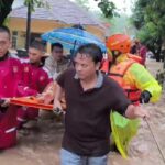 Sejumlah anggota Polres Sukabumi mengevakuasi ibu dan bayi dari gang sempit yang diterjang banjir bandang. Foto: Polri