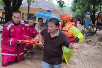 Sejumlah anggota Polres Sukabumi mengevakuasi ibu dan bayi dari gang sempit yang diterjang banjir bandang. Foto: Polri