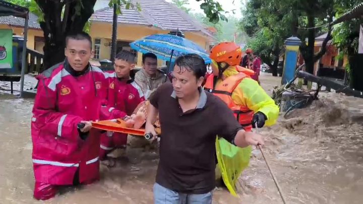 Sejumlah anggota Polres Sukabumi mengevakuasi ibu dan bayi dari gang sempit yang diterjang banjir bandang. Foto: Polri