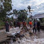 Tim gabungan tengah membersihkan sejumlah material kayu menyumbat jembatan desa akibat banjir bandang menerjang Desa Gunungsari, Kabupaten Bondowoso, Jumat (10/1/2025). Foto: BPBD Kabupaten Bondowoso