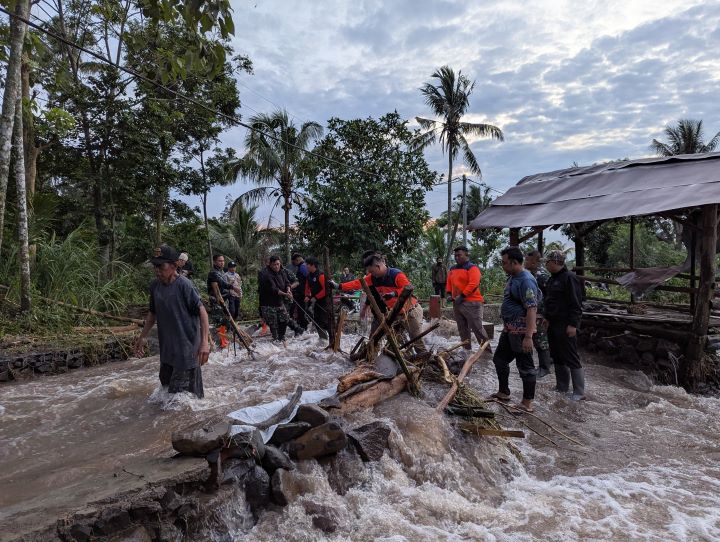 Tim gabungan tengah membersihkan sejumlah material kayu menyumbat jembatan desa akibat banjir bandang menerjang Desa Gunungsari, Kabupaten Bondowoso, Jumat (10/1/2025). Foto: BPBD Kabupaten Bondowoso