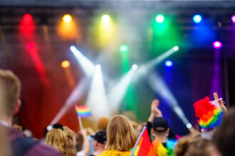 Ilustrasi, pesta atau festival dengan bendera dan sorotan berwarna-warni, LGBT. Foto: Istock @nrqemi