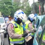 Aparat Polantas Polri melakukan penilangan di tempat kepada sejumlah pengendara mobil yang nekat parkir sembarangan di wilayah Jakarta Timur. Foto: Dok/ipol.id