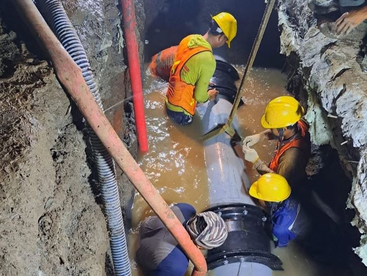 Petugas PAM Jaya saat melakukan pemasangan pipa. (foto istimewa)