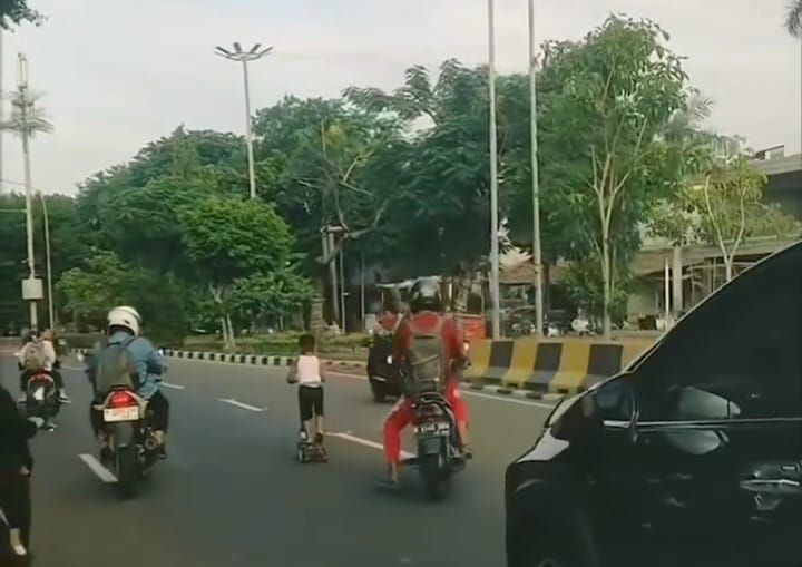 Terekam video anak laki-laki asyik bermain skuter di tengah Jalan Dr Sumarno, Kelurahan Penggilingan, Kecamatan Cakung, Jakarta Timur, hingga viral di media sosial, Senin (13/1/2025). Foto: Ist