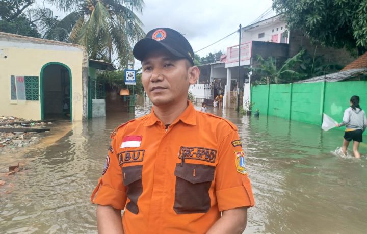 Komandan Regu B Badan Penanggulangan Bencana Daerah (BPBD) Korwil Jakarta Timur, Abu melaporkan dari lokasi banjir permukiman warga di RT 04/RW 06, Kelurahan Cakung Barat, Kecamatan Cakung, Jakarta Timur, pada Rabu (29/1/2025). Foto: Joesvicar Iqbal/ipol.id