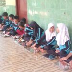 Suasana sejumlah murid sekolah dasar di wilayah Susukan, Ciracas, Jakarta Timur, saat mendapatkan makan bergizi gratis (MBG) dengan menu disajikan pada 6 Januari 2025 meliputi nasi, ayam, tahu, sayur bayam dan jagung, dan semangka. Foto: Ist