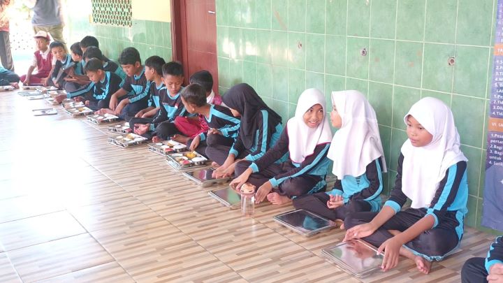 Suasana sejumlah murid sekolah dasar di wilayah Susukan, Ciracas, Jakarta Timur, saat mendapatkan makan bergizi gratis (MBG) dengan menu disajikan pada 6 Januari 2025 meliputi nasi, ayam, tahu, sayur bayam dan jagung, dan semangka. Foto: Ist