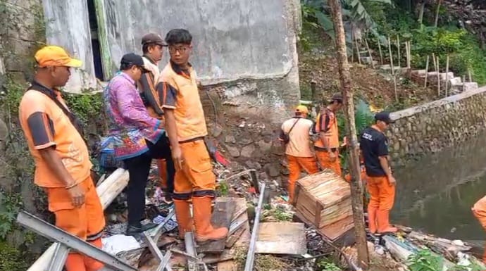 Sejumlah pasukan PPSU menangani tanah longsor yang berdampak pada satu unit rumah warga tergerus di Jalan Garuda IV, RT 12/03, Kelurahan Cibubur, Kecamatan Ciracas, Jakarta Timur, pada Kamis (6/2/2025). Foto: Ist