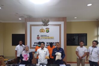 Kanit Krimsus Polres Metro Jakarta Selatan (Jaksel), AKP Indra Darmawan (tengah) bersama Ketua Tim Intelijen dan Penyidikan Balai Besar POM Jakarta, Aam Aminah (kiri) dan humas Polres Metro Jaksel menunjukkan barang bukti hasil pengungkapan kasus home industri pembuatan kosmetik ilegal tanpa izin edar dan dua tersangka inisial MS, 35, dan R, 37, di Mapolres Jaksel, pada Senin (24/2/2025). Foto: Joesvicar Iqbal/ipol.id