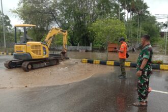 Kondisi banjir di wilayah Kabupaten Paser, Provinsi Kalimantan Timur, pada Minggu (23/2/2025). Kendaraan alat berat dikerahkan untuk menjebol trotoar jalan. Foto: BPBD Kabupaten Paser