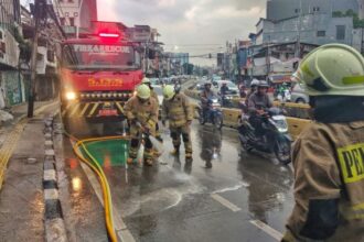 Sejumlah petugas Damkar melakukan penyemprotan membersihkan tumpahan oli dari angkutan umum di Jalan Jatinegara Barat, RT 008 RW 004, Kelurahan Bali Mester, Kecamatan Jatinegara, Jakarta Timur, pada Senin (10/2/2025) sore. Foto: Ist