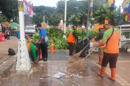 Petugas bekerja membersihkan sampah pasca acara pelantikan kepala daerah. Foto: Ist