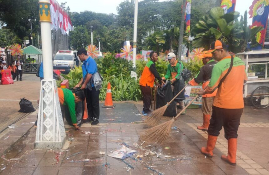 Petugas bekerja membersihkan sampah pasca acara pelantikan kepala daerah. Foto: Ist