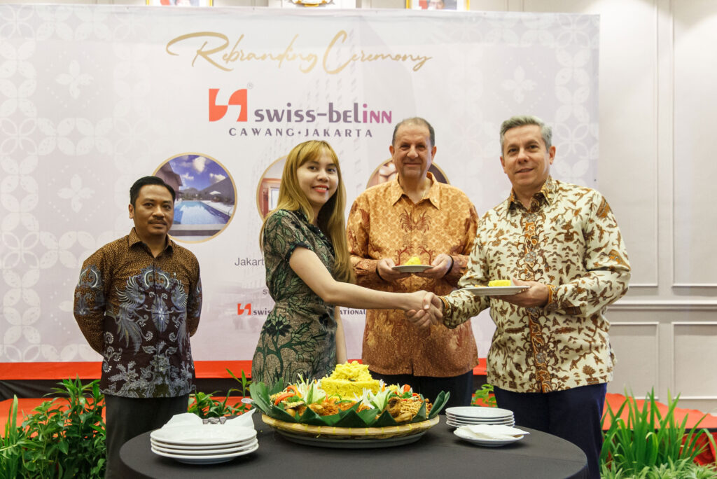 Penyerahan potongan tumpeng oleh Director of Sales & Marketing Swiss-Belinn Cawang, Yanstika Putri kepada Regional Director of Operations & Development Swiss-Belhotel International untuk Indonesia, Fabrice Mini. . (Alidrian Fahwi/ipol.id)