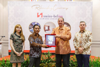 Penyerahan plakat dari Senior Vice President Operations & Development Swiss-Belhotel International untuk Indonesia, Emmanuel Guillard kepada Direktur PT Superior Coach, Ario Adhitomo pada seremoni Rebranding Swiss-Belinn Cawang, Senin (10/2/2025) pagi. (Alidrian Fahwi/ipol.id)