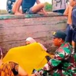 Babinsa Koramil 1201-03/Mempawah Hilir, Kodim 1201/Mempawah Sertu Amirudin saat membantu persalinan ibu hamil yang terjebak banjir di truk. Foto: Dispenad