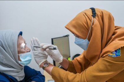 Seorang warga menggunakan fasilitas cek kesehatan gratis di puskesmas.
