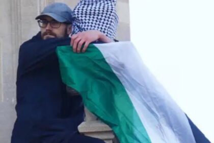 Seorang pria yang memegang bendera Palestina memanjat Menara Elizabeth, yang dikenal sebagai Big Ben, di London, Inggris Foto: X @OliLondonTV