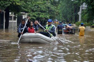 Ilustrasi, Akhibat Hujan deras warga Jakarta melintasi jalan banjir dengan perahu karet di jalan Grogol, Jakarta, Indonesia. Foto: Istock @danikancil