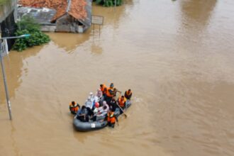 Petugas Badan Nasional Penanggulangan Bencana (BNPB) dan Badan Penanggulangan Bencana Daerah (BPBD) Kota Jakarta Timur menggunakan perahu karet mengevakuasi warga RT 1 hingga RT 13 dan 14, Cililitan, Kramat Jati, yang terjebak banjir, Selasa (4/3/2025). Foto: Joesvicar Iqbal/ipol.id