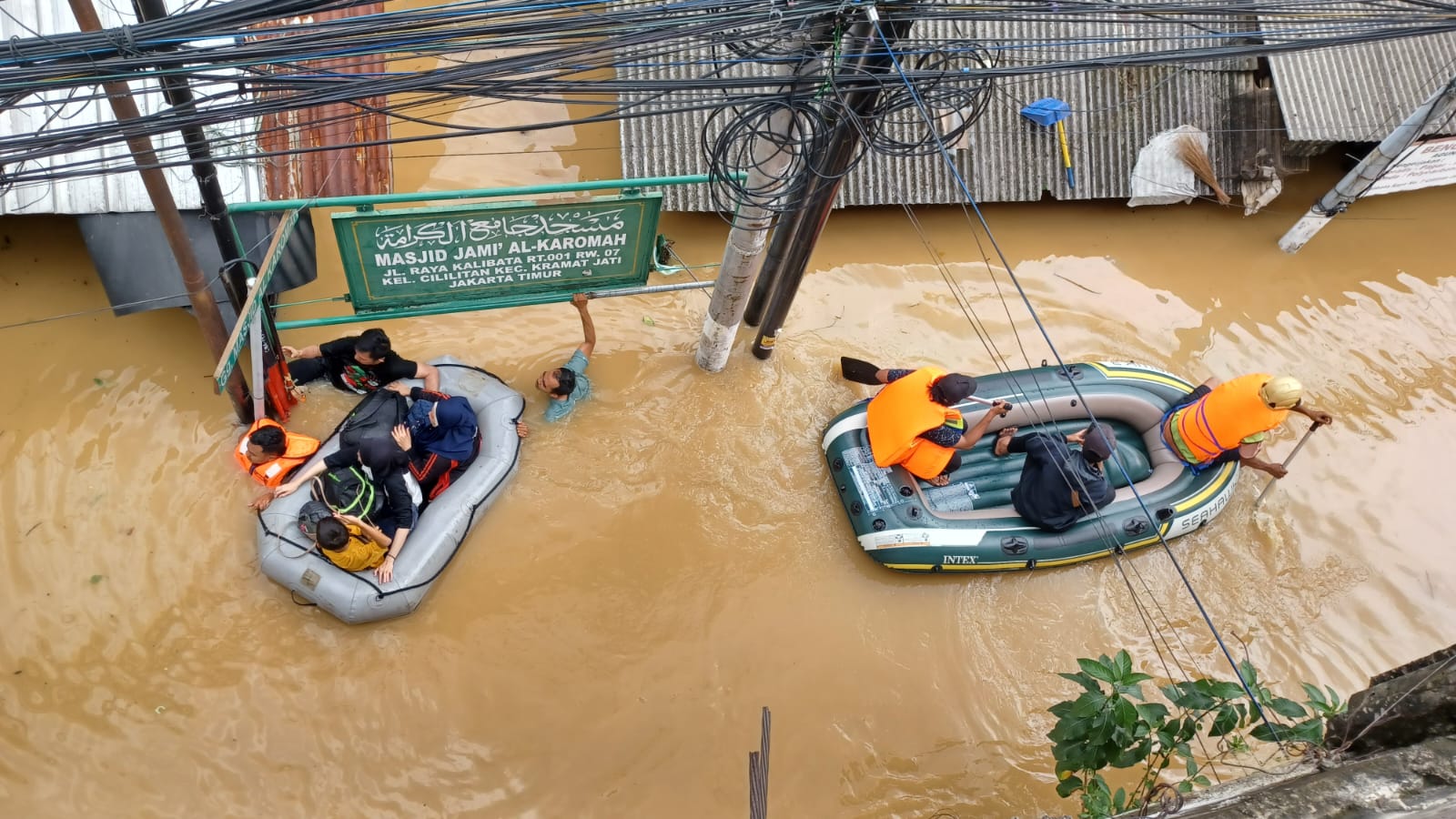 Petugas Badan Nasional Penanggulangan Bencana (BNPB) dan Badan Penanggulangan Bencana Daerah (BPBD) Kota Jakarta Timur menggunakan perahu karet mengevakuasi warga RT 1 hingga RT 13 dan 14, Cililitan, Kramat Jati, yang terjebak banjir, Selasa (4/3/2025). Foto: Joesvicar Iqbal/ipol.id