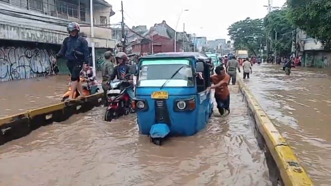 Kondisi banjir di Jalan Jatinegara Barat, Kecamatan Jatinegara, Jakarta Timur, pada Selasa (4/3/2025), sejumlah kendaraan bermotor banyak mengalami mesin mati atau mogok hingga harus didorong. Foto: Joesvicar Iqbal/ipol.id