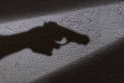 Ilustrasi, Bayangan tangan memegang pistol di tangannya. Foto: Istock @ugurhan
