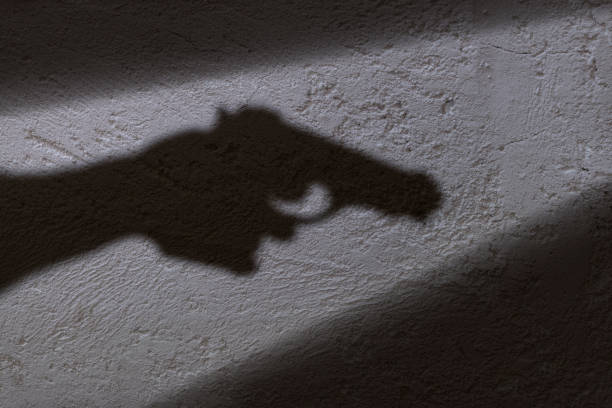 Ilustrasi, Bayangan tangan memegang pistol di tangannya. Foto: Istock @ugurhan