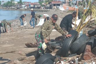 Personel Koramil 1402-01/Polewali bersama masyarakat dan pemuda setempat menggelar aksi bersih-bersih pantai di Lingkungan Ujung, Kelurahan Polewali, Kecamatan Polewali, Kabupaten Polewali Mandar, Sulawesi Barat. Foto: Koramil 1402-01/Polewali