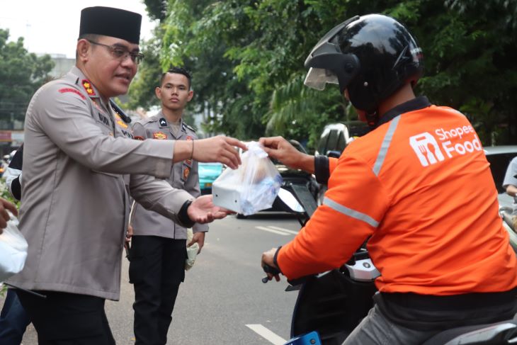 Wakapolres Metro Jakarta Selatan, AKBP Kade Budiyarta bersama Pejabat Utama (PJU) dan jajaran saat membagikan takjil kepada sejumlah pengendara di depan Mapolres Metro Jakarta Selatan, Kamis (6/3/2025) sore. Foto: Ist