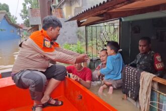 Kapolsek Bojongsari, Kompol Fauzan Thohari, turun langsung dalam proses evakuasi warga di permukiman. Foto: polri