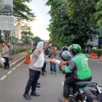 Kapolres Metro Jakarta Selatan (Jaksel), Kombes Ade Rahmat Idnal didampingi Wakapolres Jaksel, AKBP Kade Budiyarta bersama Pejabat Utama (PJU), Polwan dan awak media membagikan takjil kepada sejumlah pengendara ojek online dan pejalan kaki di depan Mapolres Metro Jakarta Selatan, Kamis (13/3/2025) sore. Foto: Joesvicar Iqbal/ipol.id