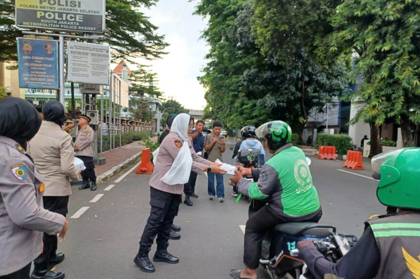 Kapolres Metro Jakarta Selatan (Jaksel), Kombes Ade Rahmat Idnal didampingi Wakapolres Jaksel, AKBP Kade Budiyarta bersama Pejabat Utama (PJU), Polwan dan awak media membagikan takjil kepada sejumlah pengendara ojek online dan pejalan kaki di depan Mapolres Metro Jakarta Selatan, Kamis (13/3/2025) sore. Foto: Joesvicar Iqbal/ipol.id